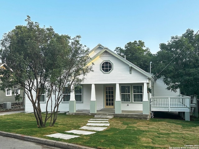 view of front of house featuring a front yard, central AC, and a wooden deck