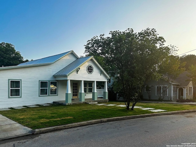 view of front of property featuring covered porch and a front yard