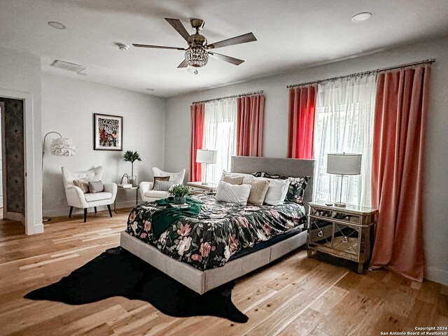 bedroom featuring hardwood / wood-style floors, multiple windows, and ceiling fan