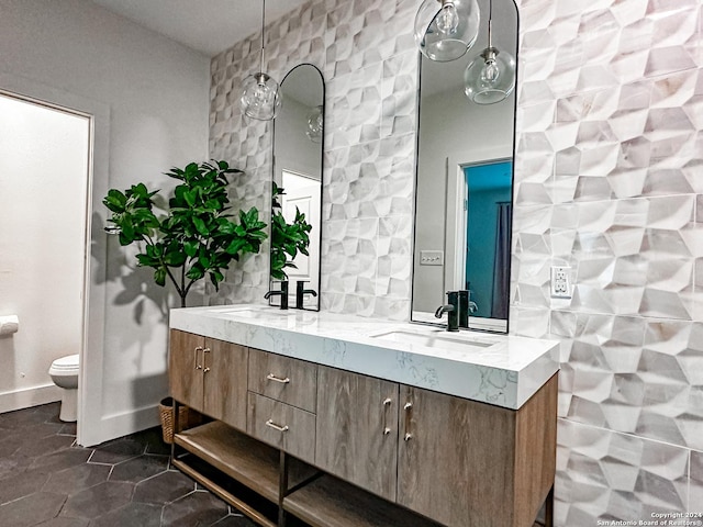 bathroom featuring toilet, vanity, tile patterned floors, and tile walls