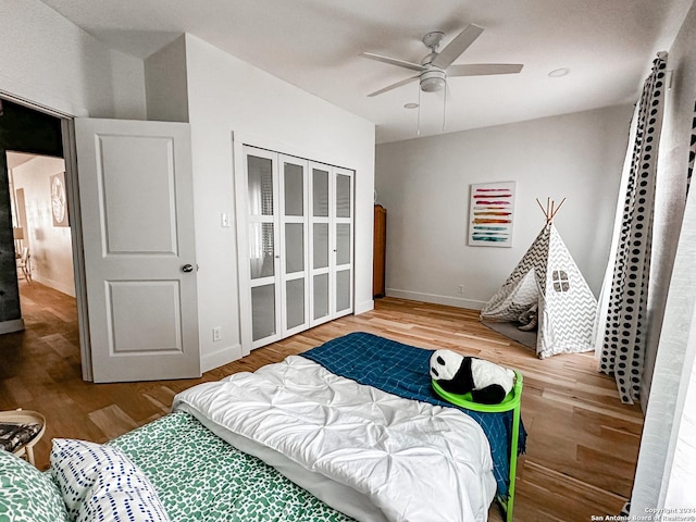 bedroom with ceiling fan, a closet, and hardwood / wood-style flooring