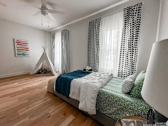 bedroom with hardwood / wood-style floors and ceiling fan