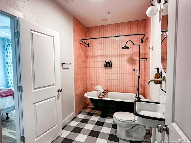 bathroom with toilet, tile walls, and tiled shower / bath