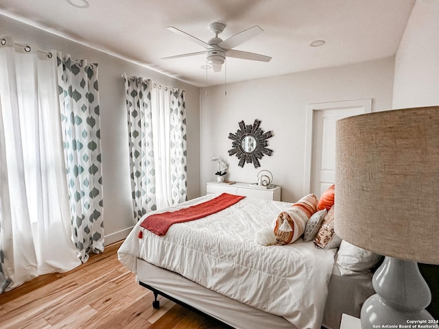 bedroom featuring multiple windows, ceiling fan, and hardwood / wood-style floors