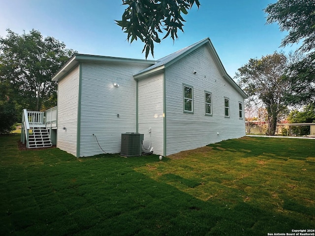 back of property featuring a yard, a wooden deck, and central air condition unit