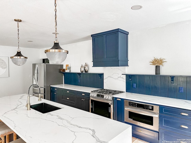 kitchen featuring blue cabinetry, appliances with stainless steel finishes, hanging light fixtures, and sink