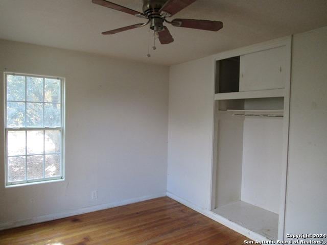 unfurnished bedroom with hardwood / wood-style flooring, ceiling fan, and a closet