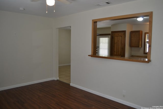 unfurnished room with ceiling fan and dark hardwood / wood-style flooring