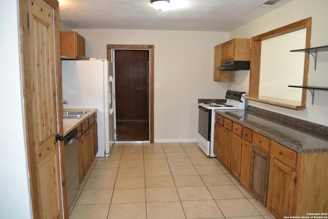 kitchen featuring sink, light tile patterned floors, and white appliances