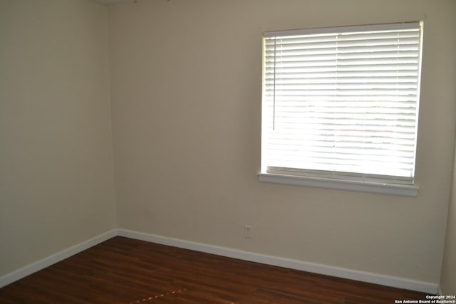 empty room with a wealth of natural light and dark wood-type flooring