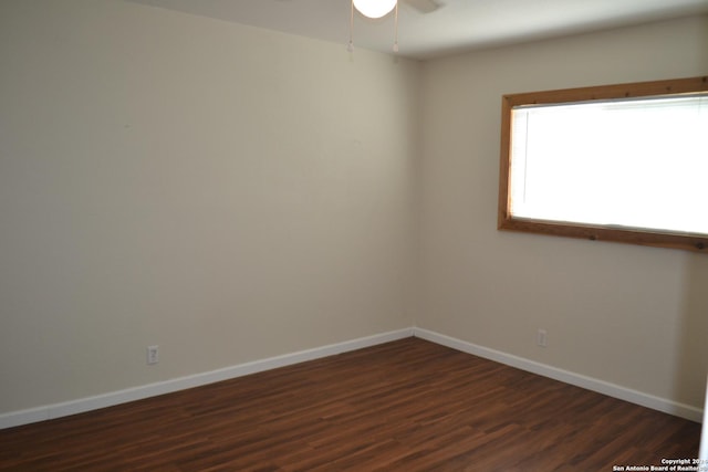 empty room featuring ceiling fan and dark wood-type flooring