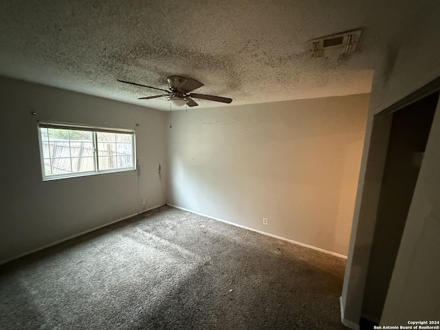 carpeted empty room with ceiling fan and a textured ceiling