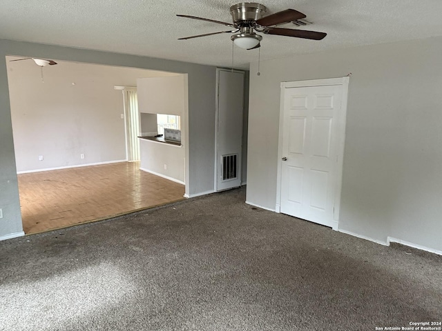 unfurnished living room with ceiling fan, a textured ceiling, and dark colored carpet