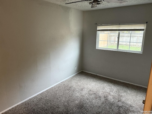 carpeted empty room featuring ceiling fan and a textured ceiling