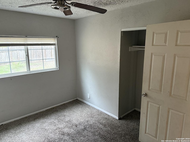 unfurnished bedroom with carpet, a textured ceiling, a closet, and ceiling fan