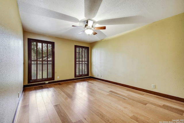 spare room featuring a textured ceiling, ceiling fan, and light hardwood / wood-style flooring