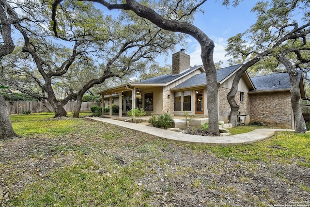 back of house featuring a patio and a lawn