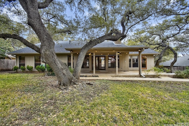 rear view of house with a patio, ceiling fan, and a yard