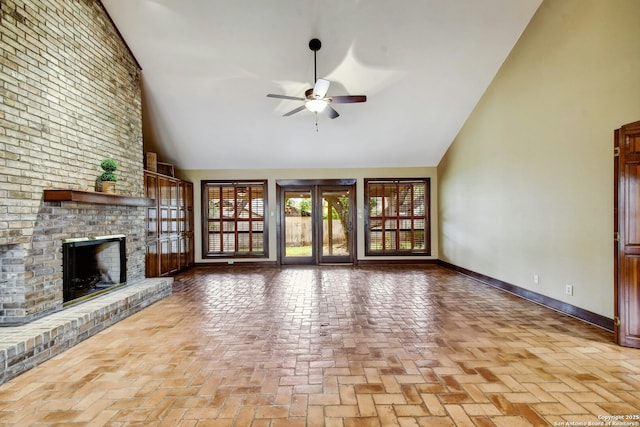 unfurnished living room with a brick fireplace, high vaulted ceiling, and ceiling fan