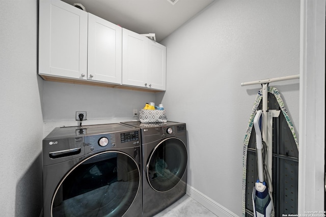 washroom with cabinets and washing machine and dryer