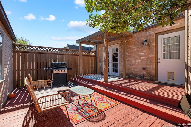 deck featuring french doors, a pergola, and area for grilling