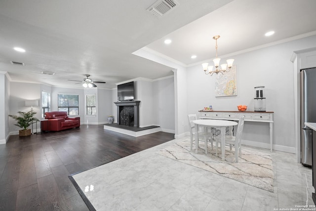 dining area featuring ceiling fan with notable chandelier, dark hardwood / wood-style flooring, and crown molding