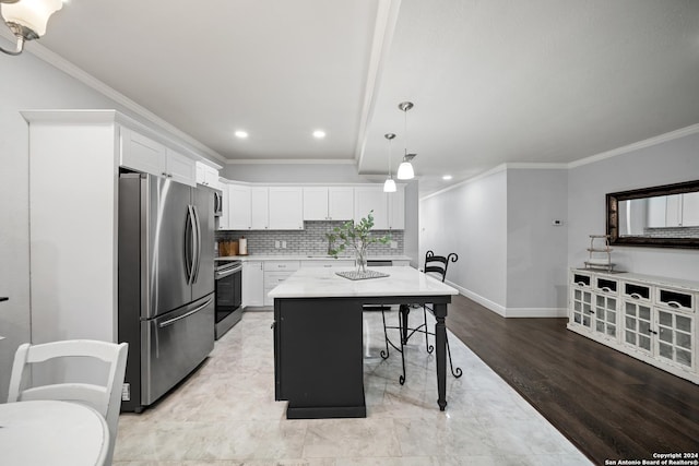 kitchen featuring a center island, light hardwood / wood-style flooring, appliances with stainless steel finishes, white cabinets, and ornamental molding