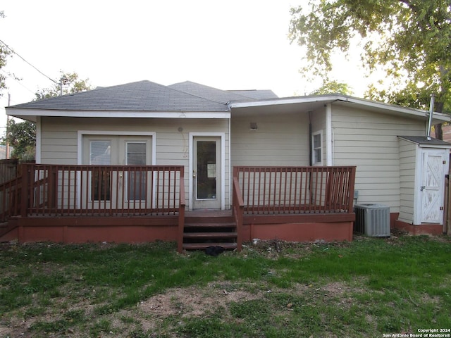 rear view of house with a yard, a deck, and cooling unit