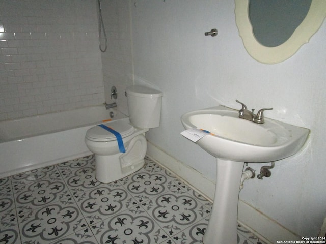 bathroom featuring tile patterned floors, toilet, and tiled shower / bath