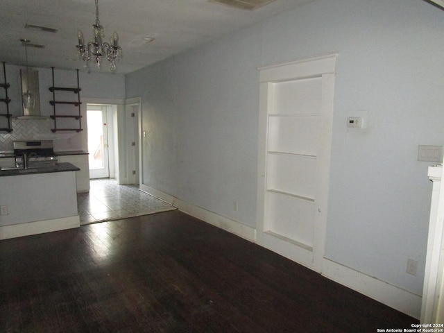 unfurnished living room with dark hardwood / wood-style flooring and an inviting chandelier