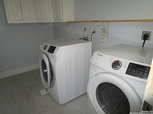 laundry area featuring washer and clothes dryer and cabinets