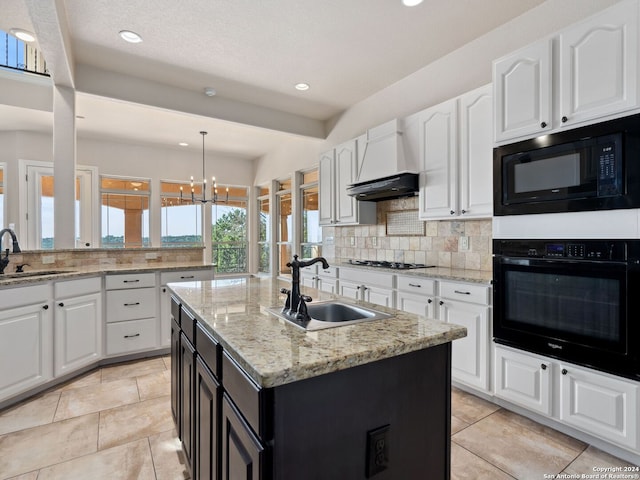 kitchen featuring a chandelier, sink, a kitchen island with sink, and black appliances