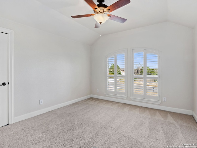 carpeted empty room with ceiling fan and vaulted ceiling