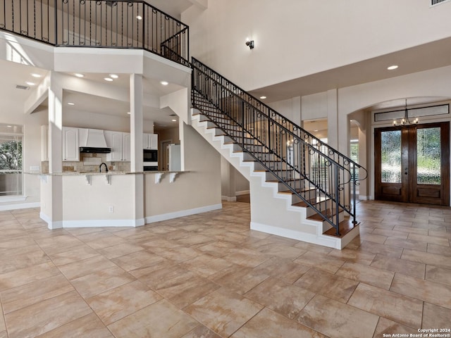 foyer entrance featuring french doors and a high ceiling