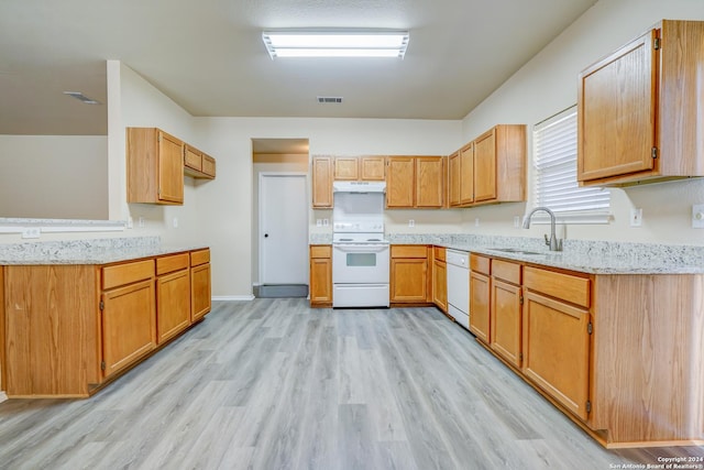 kitchen with light stone countertops, sink, white appliances, and light hardwood / wood-style flooring