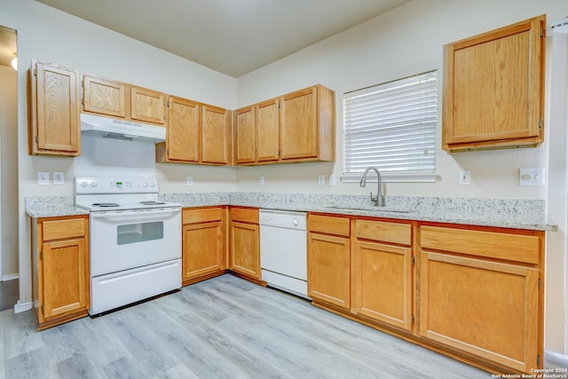 kitchen featuring light stone countertops, sink, white appliances, and light wood-type flooring