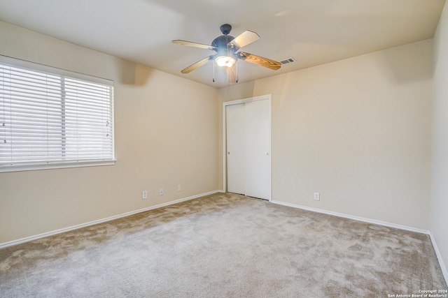 unfurnished room with light carpet and ceiling fan