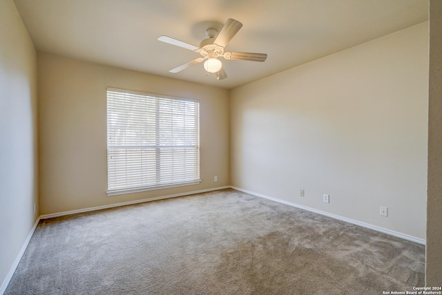 carpeted spare room with ceiling fan