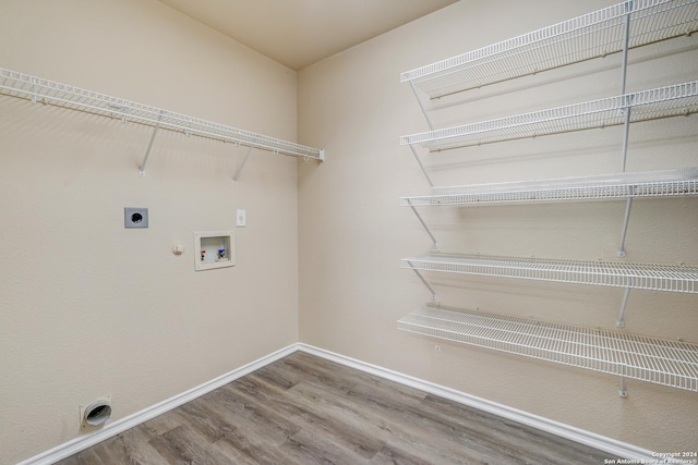 washroom featuring hookup for an electric dryer, gas dryer hookup, hardwood / wood-style flooring, and washer hookup