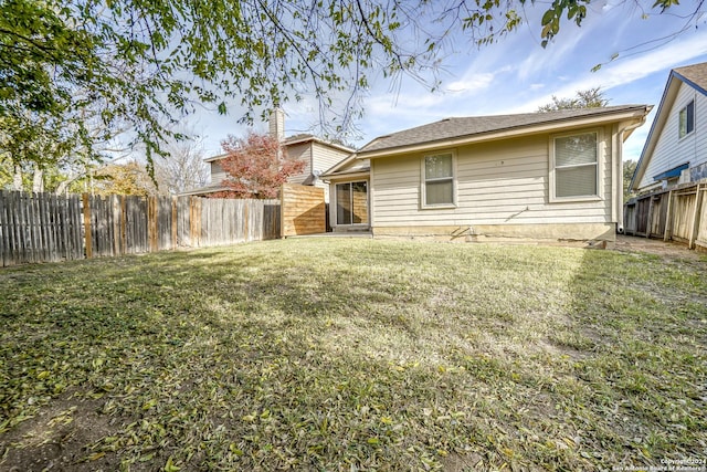 rear view of house featuring a lawn