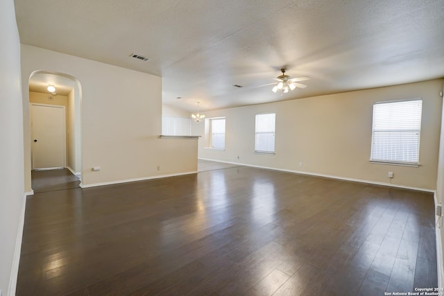 spare room with a textured ceiling, ceiling fan with notable chandelier, and dark hardwood / wood-style floors