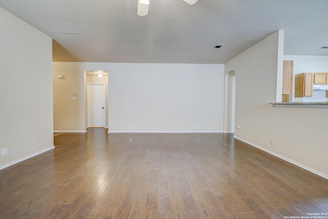 unfurnished living room featuring dark hardwood / wood-style floors and ceiling fan