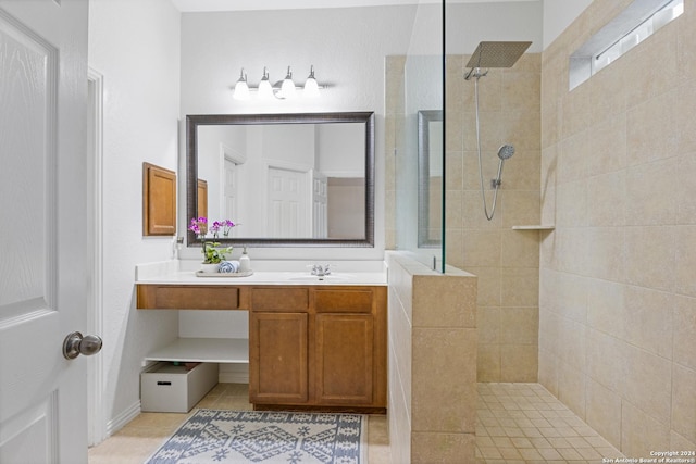 bathroom with tile patterned flooring, vanity, and tiled shower