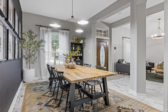 dining space featuring hardwood / wood-style floors and an inviting chandelier