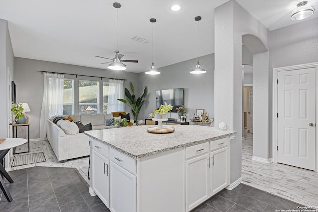 kitchen featuring white cabinets, ceiling fan, dark hardwood / wood-style floors, and light stone counters