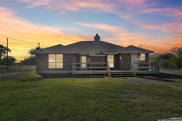 view of front of home with a deck and a yard