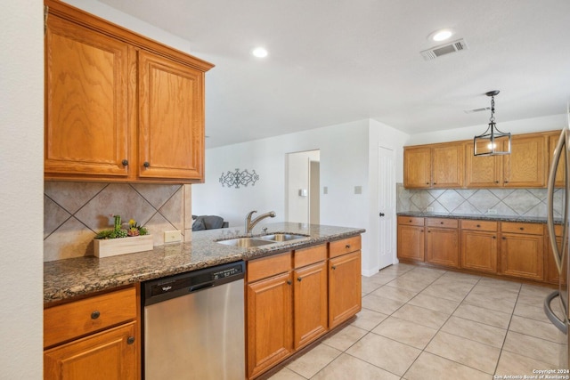 kitchen with sink, stainless steel dishwasher, backsplash, dark stone counters, and pendant lighting