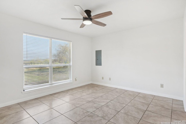 empty room featuring electric panel, ceiling fan, and light tile patterned flooring