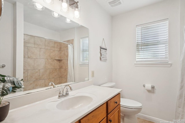 bathroom featuring walk in shower, vanity, and toilet