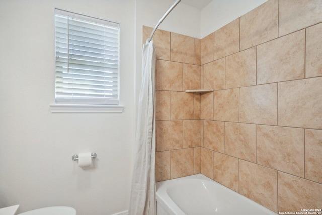 bathroom featuring toilet and shower / bath combo with shower curtain